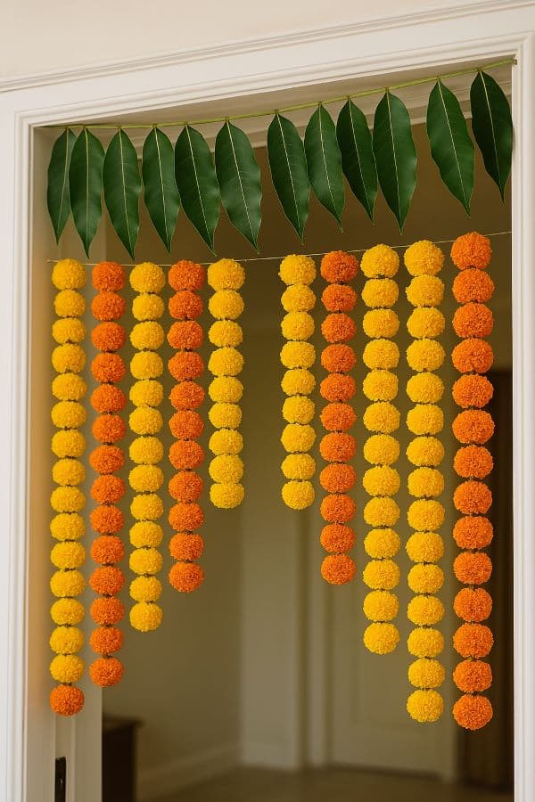 Door decorated with mango leaf toran and rangoli